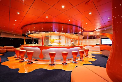 If an artist walked through a lounge and splashed buckets of bright paint across the walls and furniture, it might look like the bold, whimsical interior of MSC Splendida's Club 33.