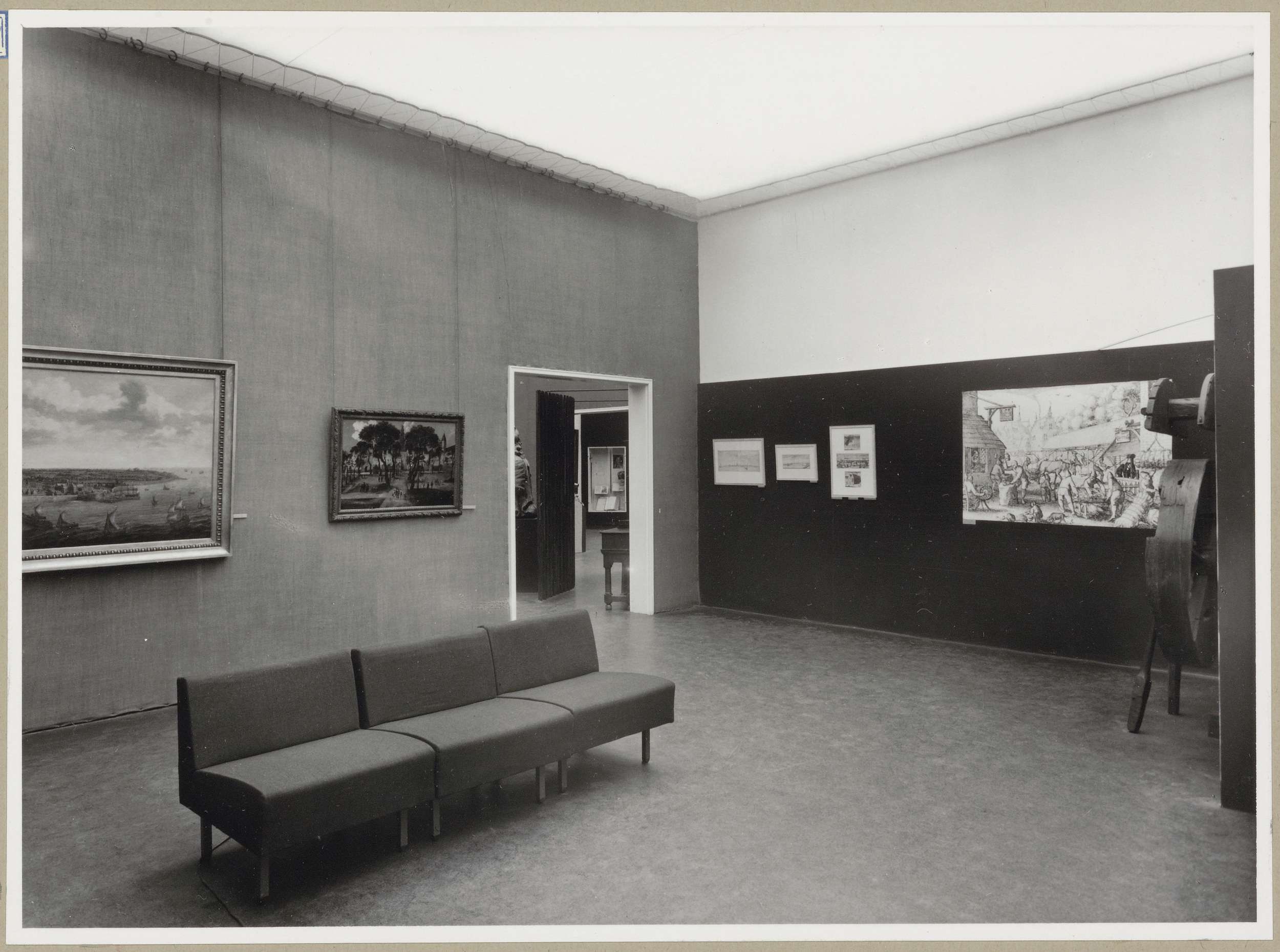 Zaal met links een doorgang en rechts een wiel