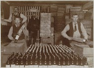 Mannen verpakken gebottelde flessen drank in kratten