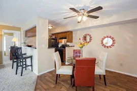 Model unit dining room with  neutral walls, white trim, ceiling fan, and wood-inspired flooring