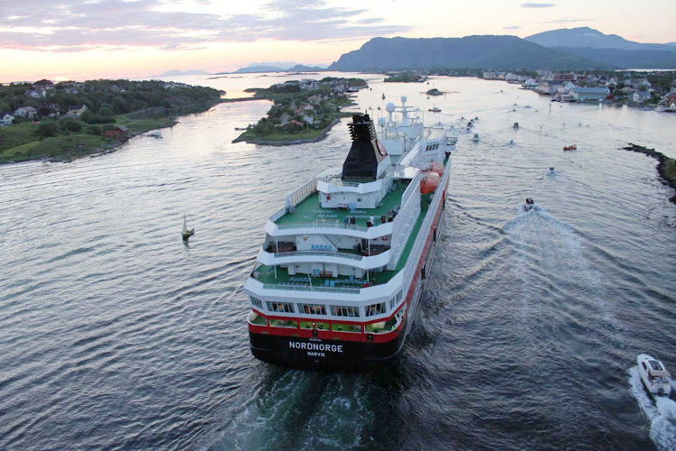 Hurtigruten's Nordnorge receives a caravan of well-wishers as she sails down the narrow peninsula into the village of Brønnøysund, Norway. 