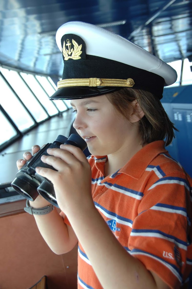 A young cruiser visits the bridge and views the horizon on a Crystal cruise.