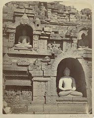 Vier nissen in de Borobudur met daarin Boeddha figuren in dhyanamudra.