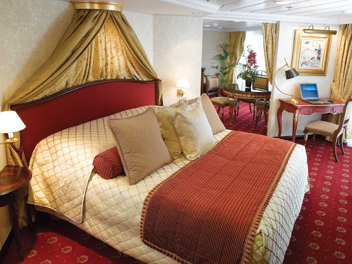 Oceania-Owners-Suite-R - Spanning nearly 1,000 square feet, the Owner's Suite aboard Oceania Nautica includes a queen bed with 1,000-thread-count linens, private teak veranda for watching the passing landscapes, a second bathroom, two flat-screen TVs, laptop, iPad, 24-hour butler service, complimetary in-suite bar setup, priority embarkation and more. 