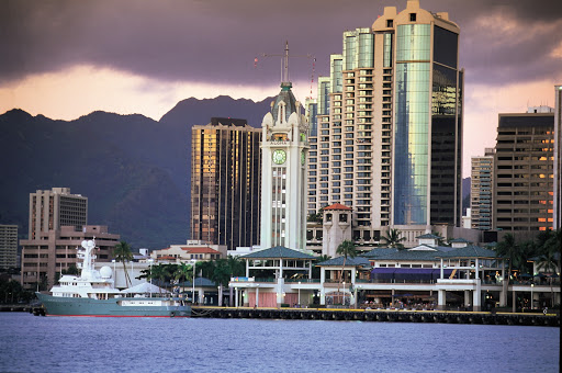 Aloha Tower Marketplace and downtown Honolulu skyline at dusk.