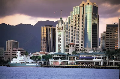 Aloha Tower Marketplace and downtown Honolulu skyline at dusk.