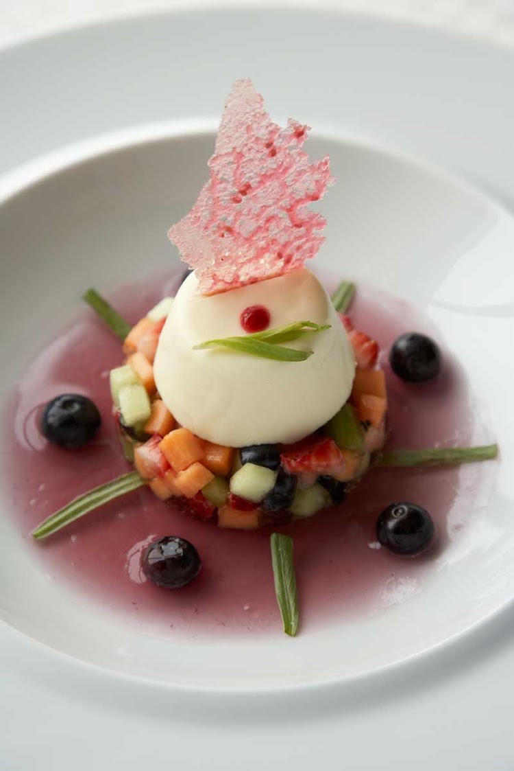 Blu restaruant's creamy Pannacotta served on a fresh fruit salad with a berry compote is one of the artfully presented desserts served on your Celebrity cruise.