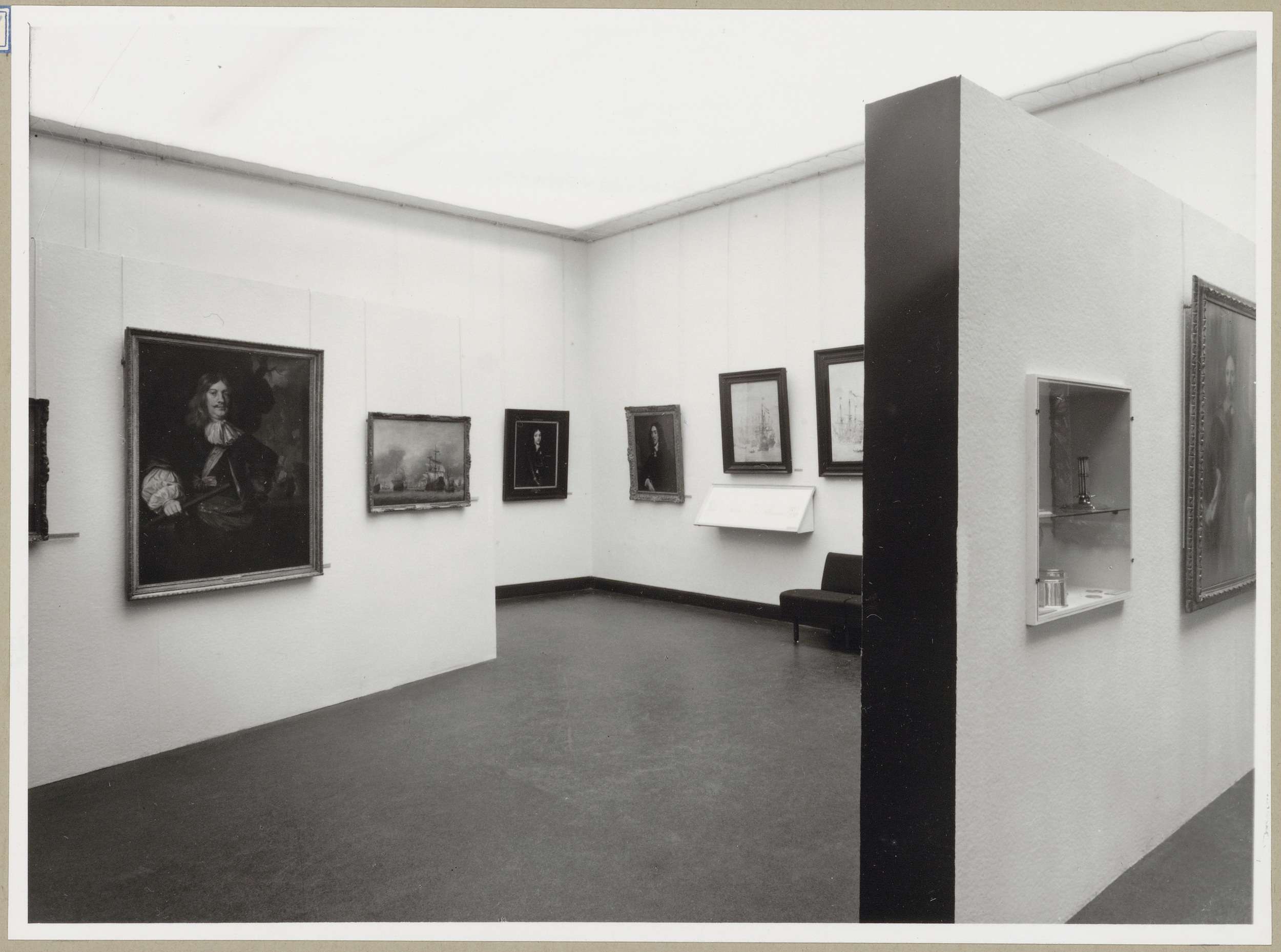 Zaal met portretten en afbeeldingen van schepen, rechtsvoor een wand met een vitrine
