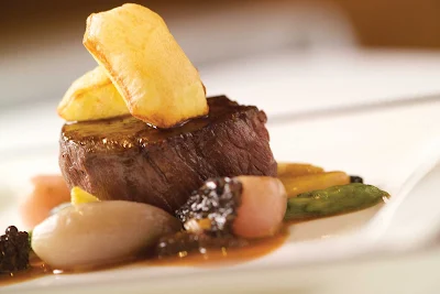 A French steak entrée prepared by the Verandah Restaurant aboard Queen Elizabeth.