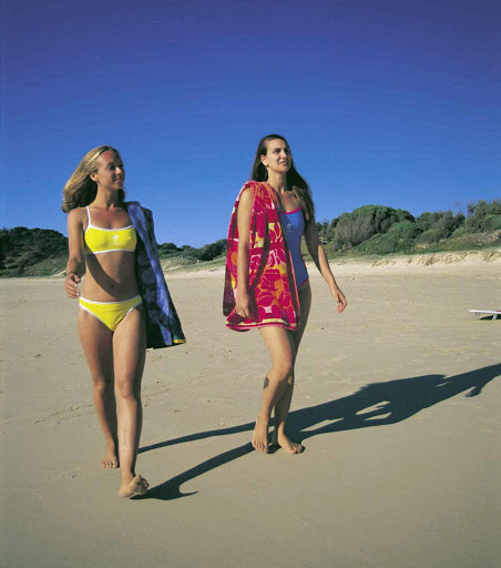 Two women stroll along the beach at Hat Head, near South West Rocks, Kempsey, North Coast NSW, Australia. 