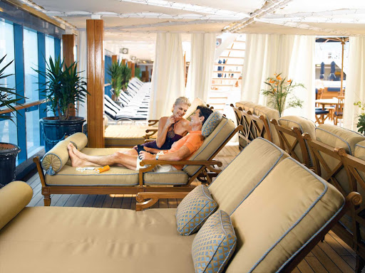 Oceania-Couple-on-Patio-2 - Unwind and enjoy the serenity of Oceania Nautica's Patio lounge area while taking in the view.