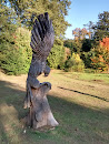 Drewniana rzeźba orła na polanie