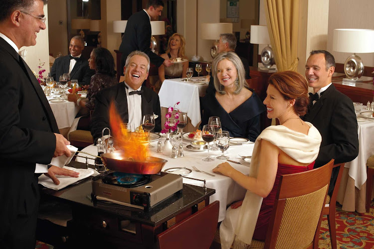 A traditional flambé dish is prepared for guests in the dining room of Queen Mary 2.