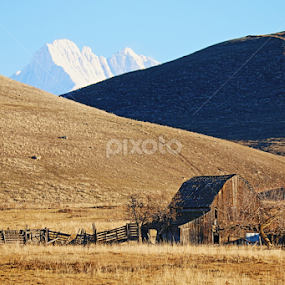 old barn with snow covered mountain behind hills by Tiecha Broussard - Buildings & Architecture Decaying & Abandoned