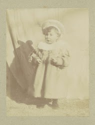 Portret van een jong kind in een jurk met een muts