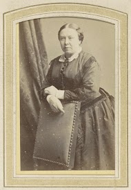 Portret van een vrouw in een jurk leunend op een stoel