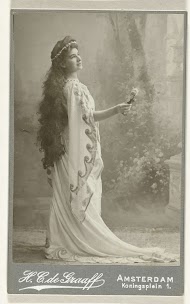 Studioportret van een vrouw in theaterkleding met in haar rechterhand een roos