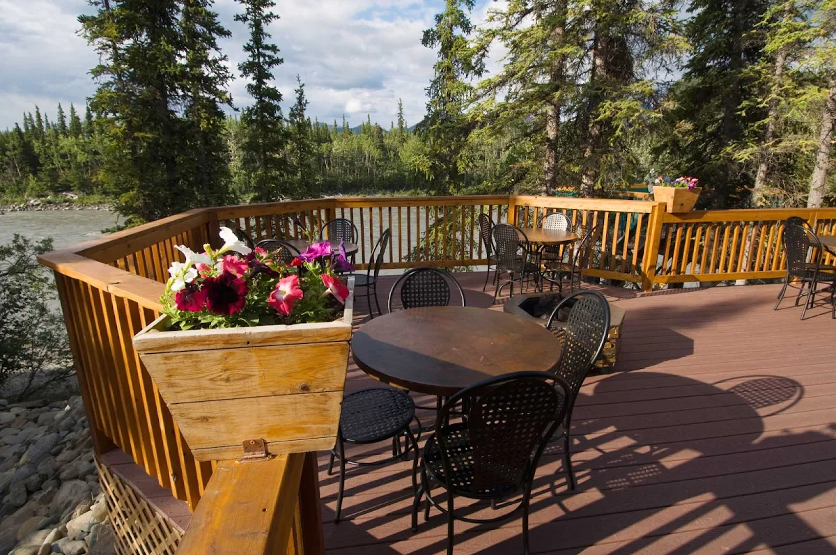 deck-McKinley-chalet-Denali - The McKinley Chalet Resort is in the heart of the Denali Canyon on the banks of the Nenana River, less than 2 miles from the entrance to Denali National Park. In summer, dining on the deck gives you a great view of the scenic vistas.