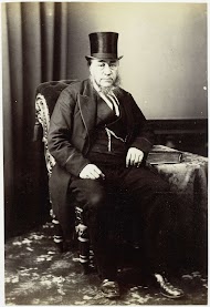 Portret van Paul Kruger met hoge hoed, zittend in een stoel