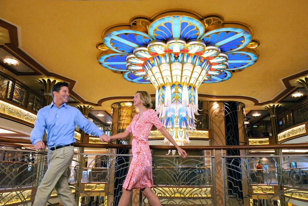 Disney-Dream-couple-by-chandelier - A colorful chandelier adorns the atrium of Disney Dream.