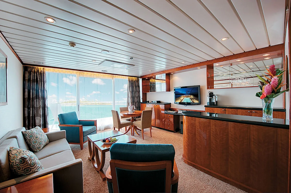 Owners_Suite_Paul_Gauguin_7002B - Owner's Suite 7002 on the Paul Gauguin features butler service and can accommodate up to four guests by adding two berths with a queen-size sofa bed. The bathroom includes a full-size tub and dressing area.