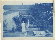 Vrouw en kind staand voor een huis