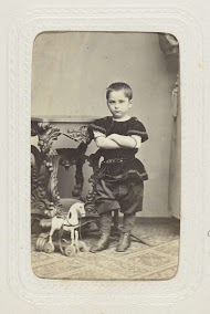 Studioportret van een jongetje met een houten paard bij een tafel