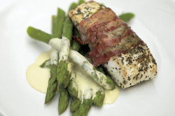 Delicious roasted white fish wrapped in smoked bacon with lemon mayonnaise and asparagus