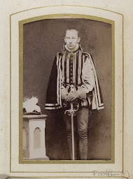 Portret van een jonge man in kostuum naast een sokkel