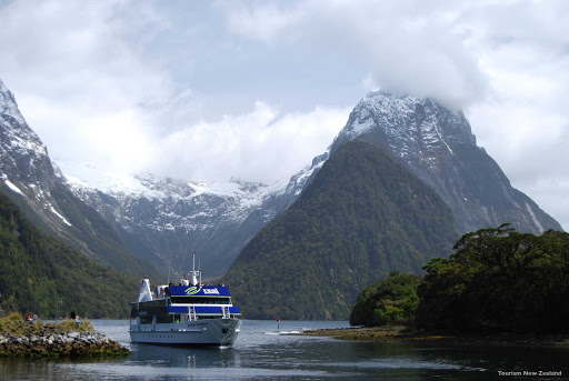 Cruise_Milford_Sound - At Milford Sound the landscape has an almost palpable spirit. Carved by ancient glaciers, these steep-sided fjords dwarf the boats that cruise their deep, clear waters. High above you can see hanging valleys, their ends sliced off by a passing glacier, release giant waterfalls down the walls of the fjord to the sea below.