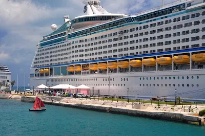 Opposites attract: a tiny dinghy next to the mega cruise ship Explorer of the Seas. 