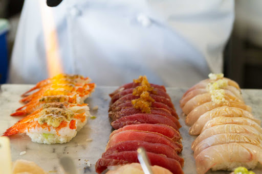 salmon-miku-Vancouver-British-Columbia - A chef flame-sears salmon oshi sushi at Miku restaurant in Vancouver, British Columbia.