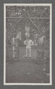 Vier kinderen hangend aan een houten hekwerk in Batoedjadjar