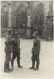 Drie Duitse soldaten voor een kerk