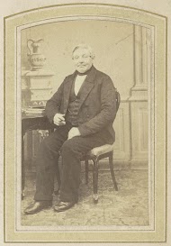 Portret van een zittende man bij een tafel