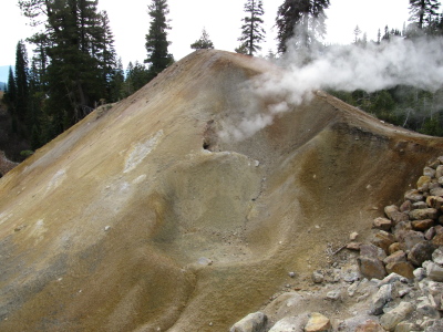 A smoking hole in a yellow mound.