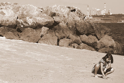 Menina brinca na areia da praia de Albarquel