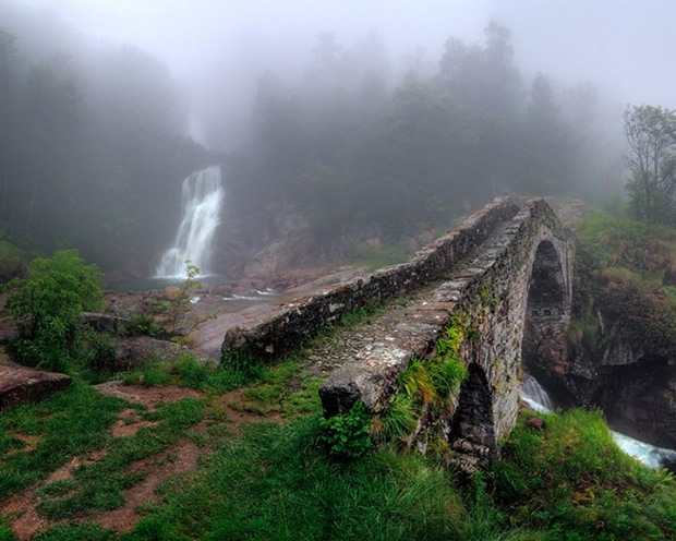 The stone bridge of Tallorno under a thick fog and some light rain in Val Chiusella, Piedmont, Italy