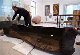 Archaeologist Dimitar Nedkov, measures the length of a well-preserved wooden vessel, likely dating back to the prehistoric age discovered at the bottom of the Black Sea