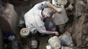 An archaeology staff member unearths the feet of a terracotta warrior at the excavation site inside the No.1 pit of the Museum of Qin Terracotta Warriors and Horses, on the outskirts of Xi'an, Shaanxi province.