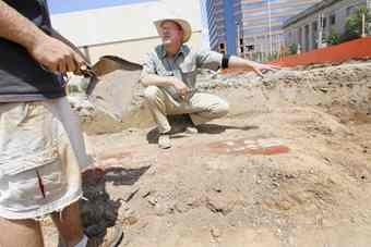 Archaeologist Hank Lutton talks with a volunteer at the dig going on at the site on the new Old Point Bank in downtown Hampton.
