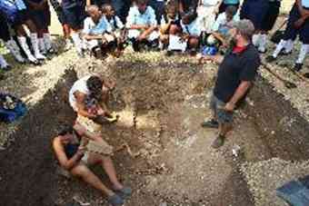 Big dig: Teacher's assistant Joel Dworsky (standing) with the help of Leonard Retter (left) and Meg Southern. Archaeology students clean up the remains of one of two cows discovered during a dig at White Hall behind St. Peters Church in St. Georges with fellow teacher's assistants and student from the College of William and Mary and share information with passing students. 