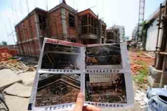 A resident shows pictures of a 900-year-old temple that was demolished to make way for a real estate project in Sixian county of Anhui province on Aug 3. [Xinhua]