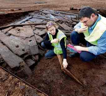 Jane Whitaker of Archaeological Development Services and Charles Mount of Bord na Móna delve into the site of the late Bronze Age wooden road in the Longford Pass bog in Co Tipperary yesterday.