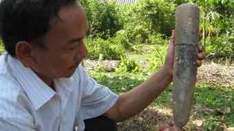 Ho Bach Khoa, a senior official from the Department of Culture, Sports and Tourism of Ha Tinh province, examines one of the pestles