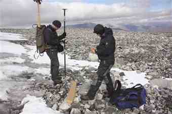 Norwegian archaeologist Trond Vihovde (L) and colleague Elling Utvik Wammer use a GPS marker to register the location of sticks used in reindeer hunting from before the Viking Age which were found beside a shrinking ice field in the Jotunheimen mountains in Norway September 9, 2010. 