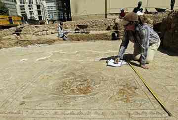 An archaeologist notes the measures of a Roman-era mosaic found at an excavation site in central Beirut.
