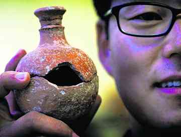 Chang-Ho Ji holds a jug from the temple in Jordan. Most of the artifacts at the site were broken, offering more corroboration that Ataroth met the violent end described on a 3,000-year-old stone slab. 