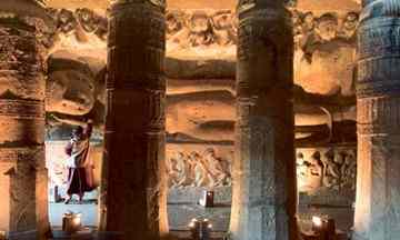 Buddhist worshiper at a reclining Buddha statue in the Chaitya hall, or prayer hall, in Cave 26 at the Ajanta Caves in India Photograph: © Richard T. Nowitz/Corbis