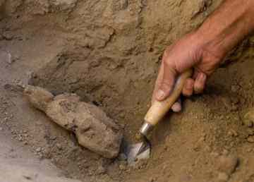 An archeologist unearths a wooden Buddha statue, estimated to be about 1,400 years old, at a sprawling 2,600-year-old Buddhist monastery in Mes Aynak, south of Kabul, Afghanistan. The archaeological dig is located at the world's second-biggest unexploited copper mine. The Chinese government-backed mining company, China Metallurgical Group Corp., which won the contract to exploit the site, has given archaeologists three years to finish the excavations. Photo: Dusan Vranic / AP 